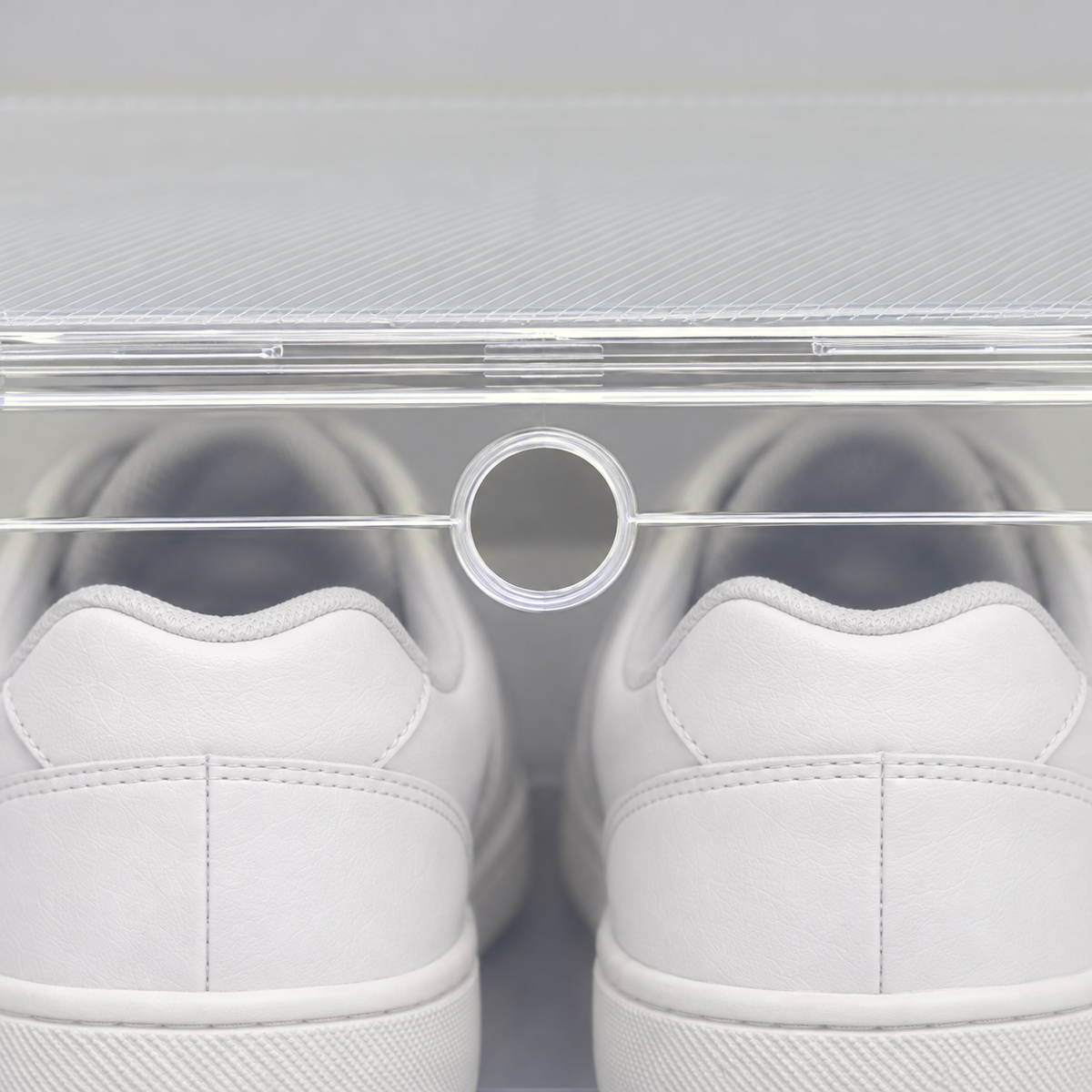 Close-up of the small round finger hole at the top of the shoe box's clear front door