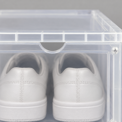 Close-up of the half-moon finger notch at the top center of a translucent shoe box door, below the molded rim