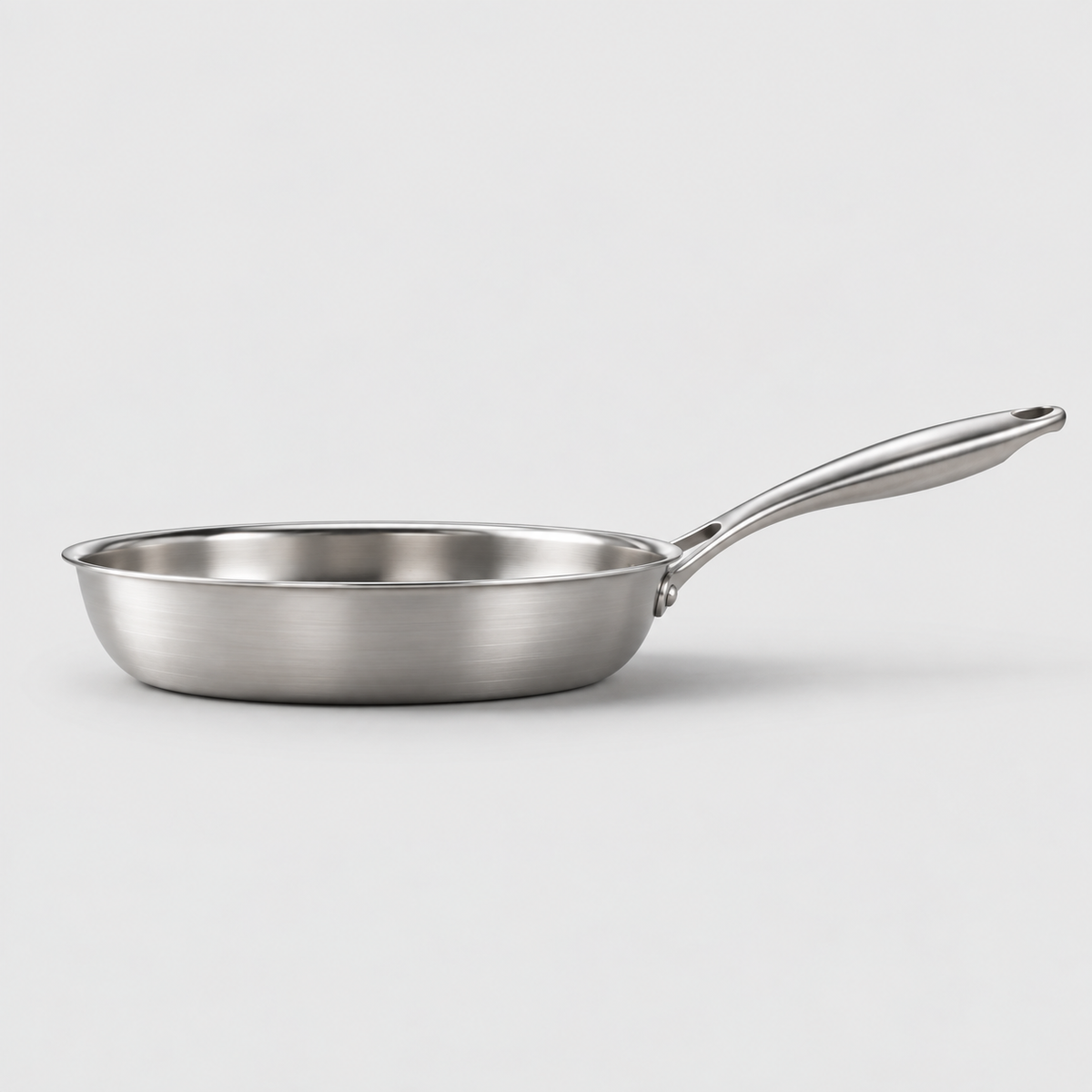 Side view of the hammered frying pan showing the low wall, rolled rim, flat base and rising handle