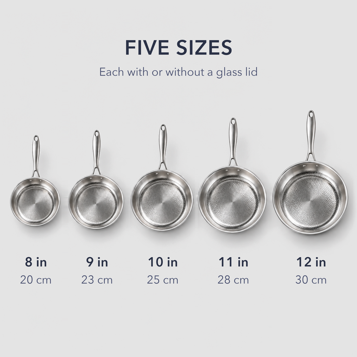Five hammered frying pans in a row from 8 to 12 inches, each labelled in inches and centimeters