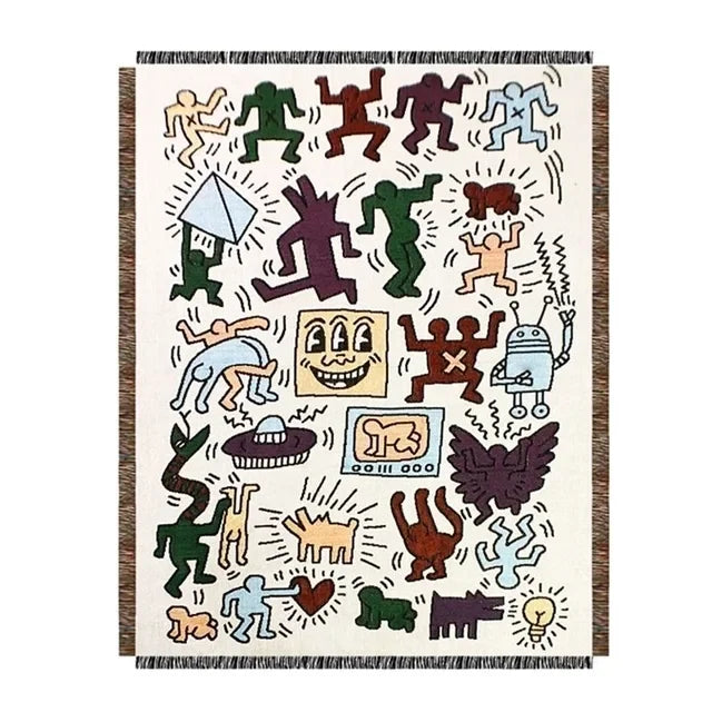 The doodle figure throw blanket laid flat on a white background, showing the full design and its fringed ends.