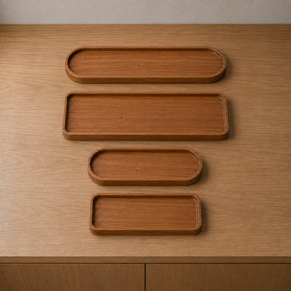 All four wooden trays together on a sideboard, two oval and two rectangular in two lengths