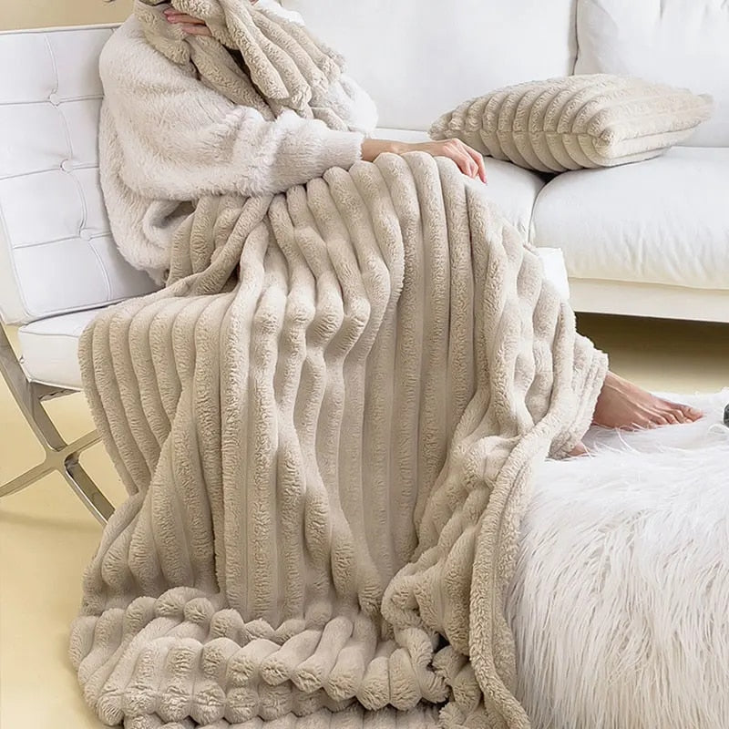 Beige faux rabbit fur throw wrapped over someone's lap on a white sofa, falling to the floor in soft pleats