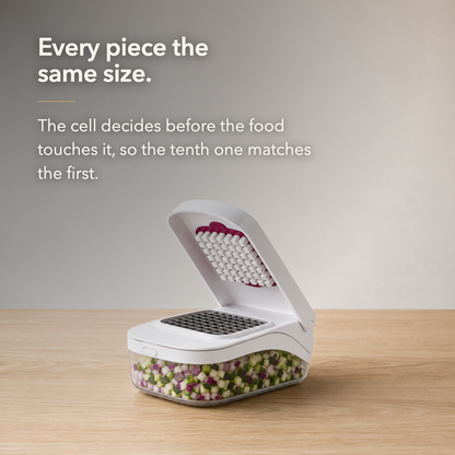 Text card reading Every piece the same size, beside the white vegetable chopper open on a wood worktop with diced vegetables in the clear container.