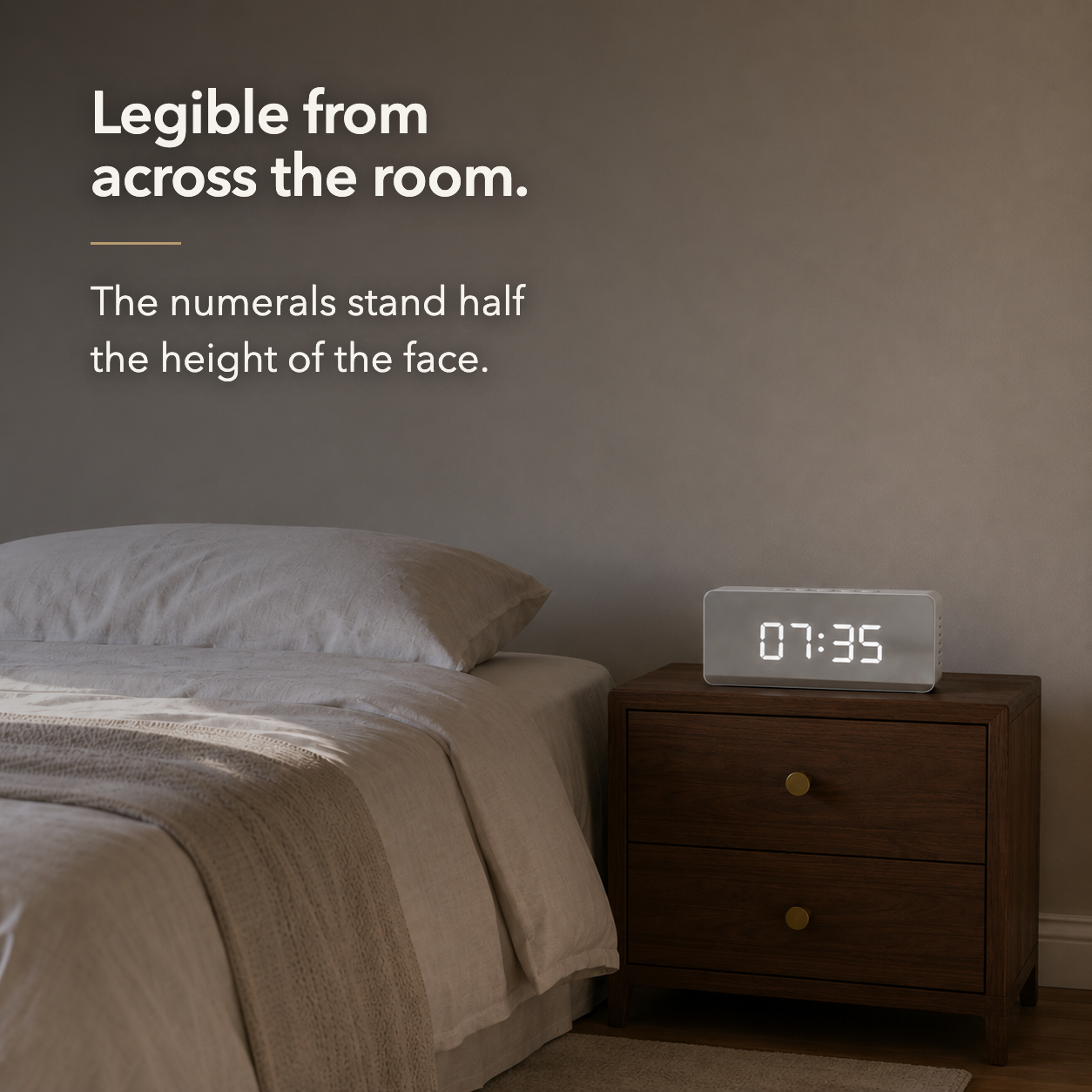 The mirror alarm clock seen from across a room, the large white digits still clearly readable at a distance