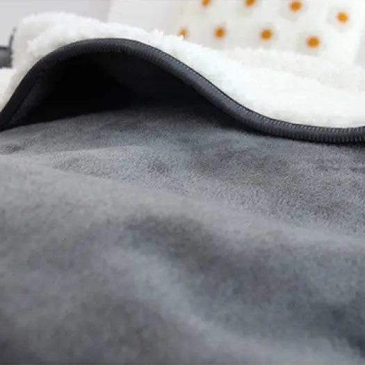 Close-up of the smooth gray flannel face, its slate bound edge and the curly fleece folded over above it