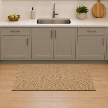 Large size beige loop pile doormat on oak floorboards in front of a kitchen sink, lying parallel with the cabinet plinth