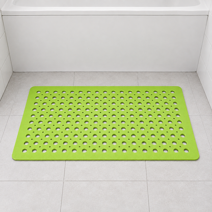 Green non slip shower mat with drainage holes on a pale tiled floor in a family bathroom