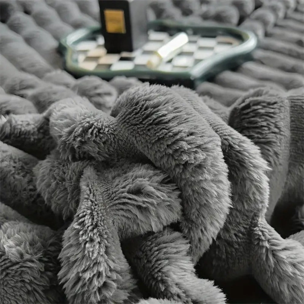 A close-up of long, soft charcoal faux fur pile gathered into a fold, with the raised ribs behind it.