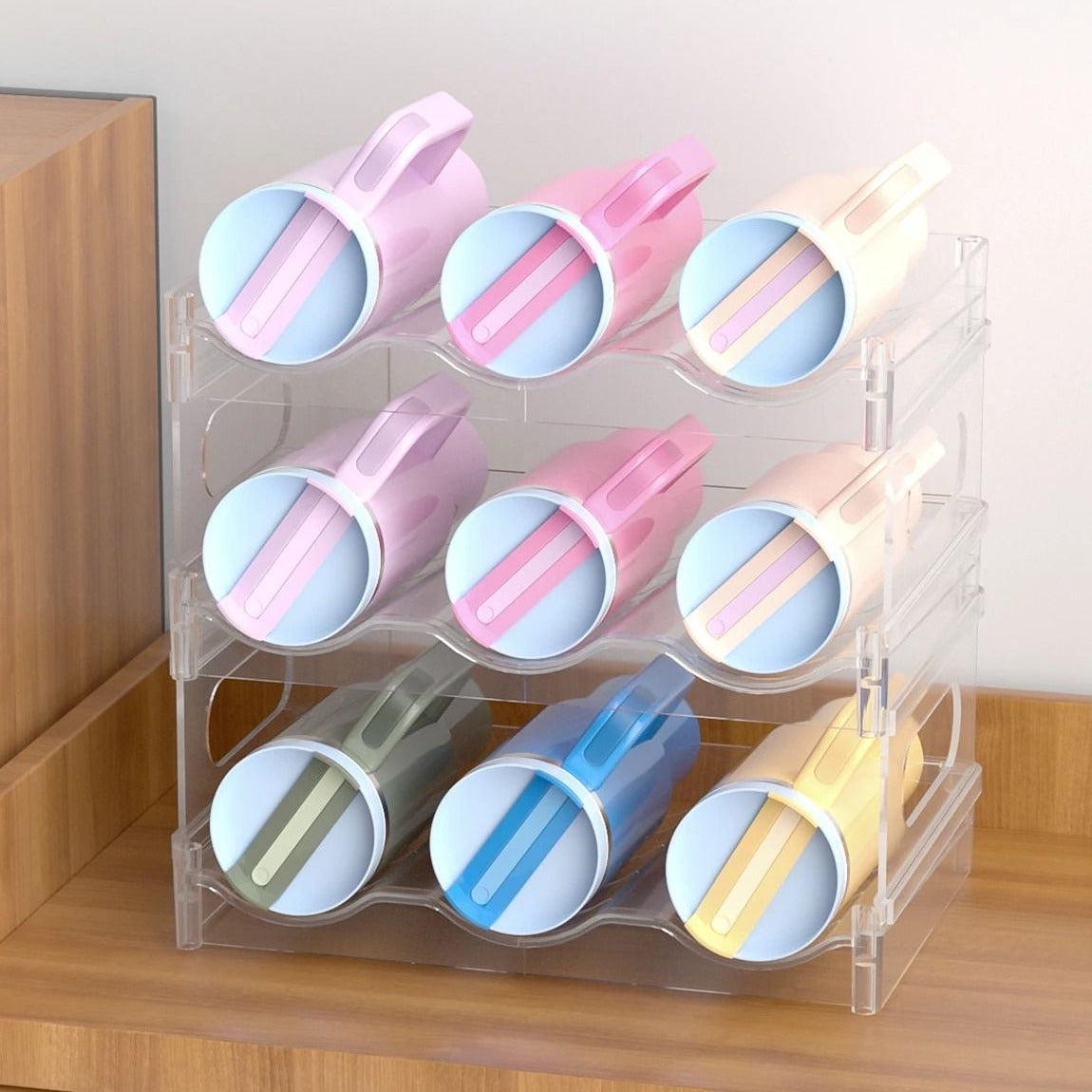 A clear three-tier bottle rack holding nine handled tumblers on their sides, on a wooden sideboard.