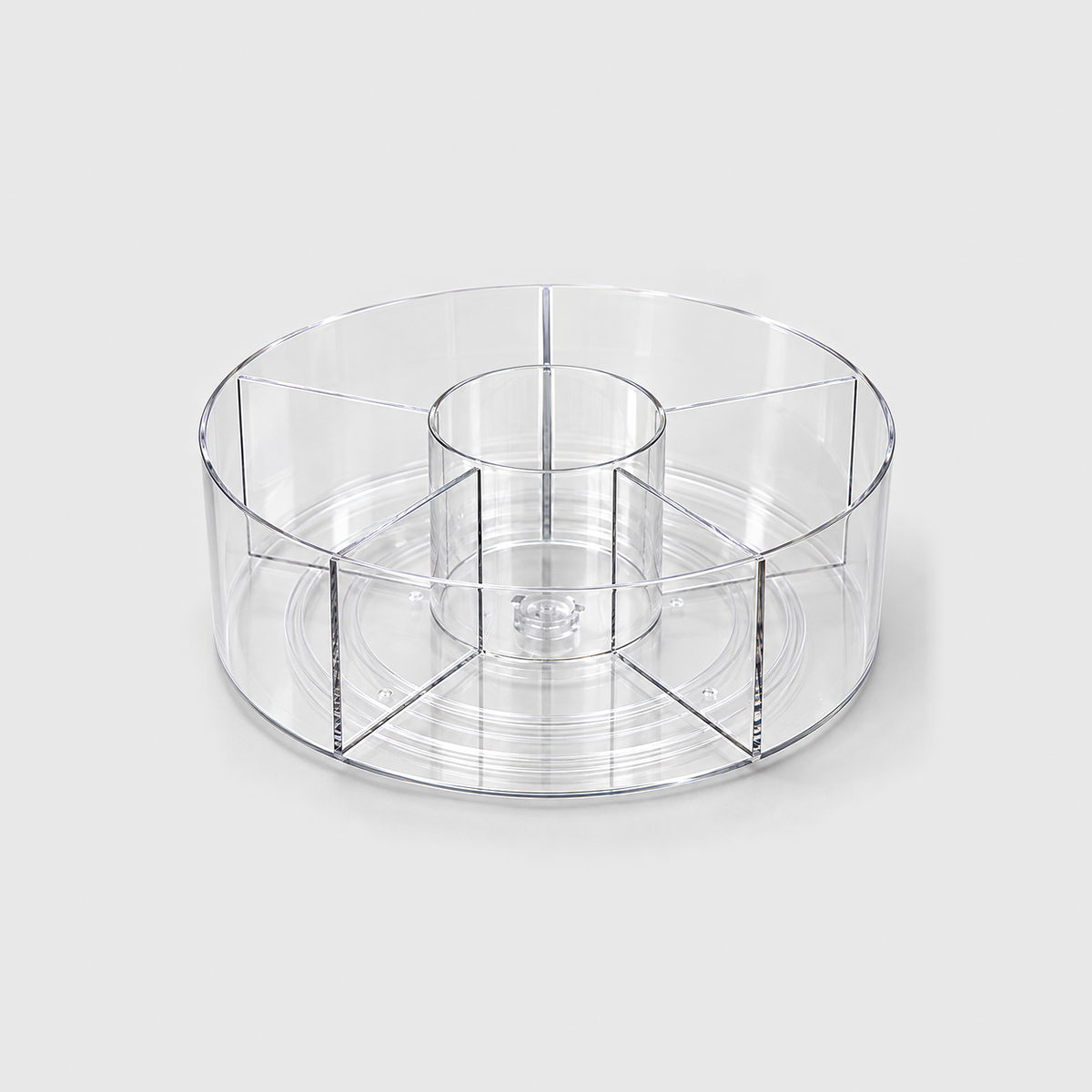 A clear round lazy Susan with a center cup and five divided sections, empty on a light grey background.