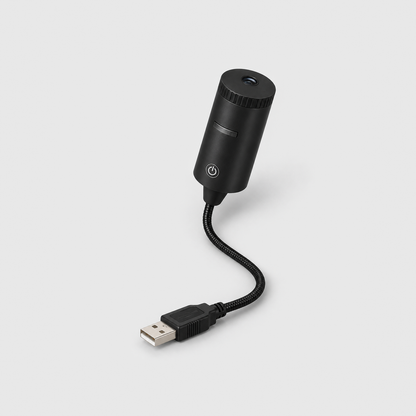 Christmas projector light on a gray background: a small black cylinder head with a ribbed top ring and power button on a flexible gooseneck ending in a USB plug