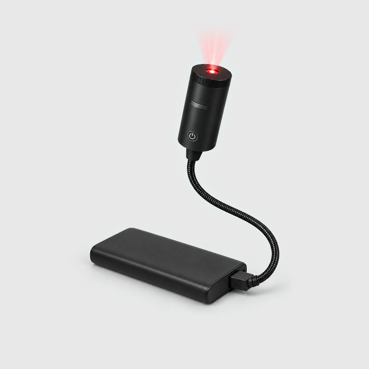 Christmas projector light switched on, its lens glowing red, the gooseneck plugged into a power bank (not included) on a gray background