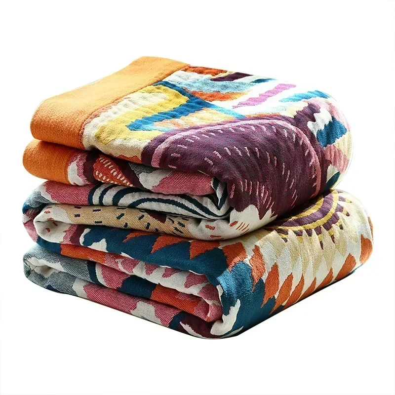 Sunburst cotton blanket folded in a stack on white, the orange border along the folded ends