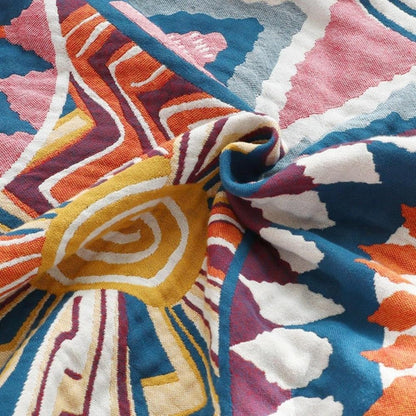 Close-up of the woven cotton gauze twisted into a swirl, a mustard spiral sun with white, blue and pink rays
