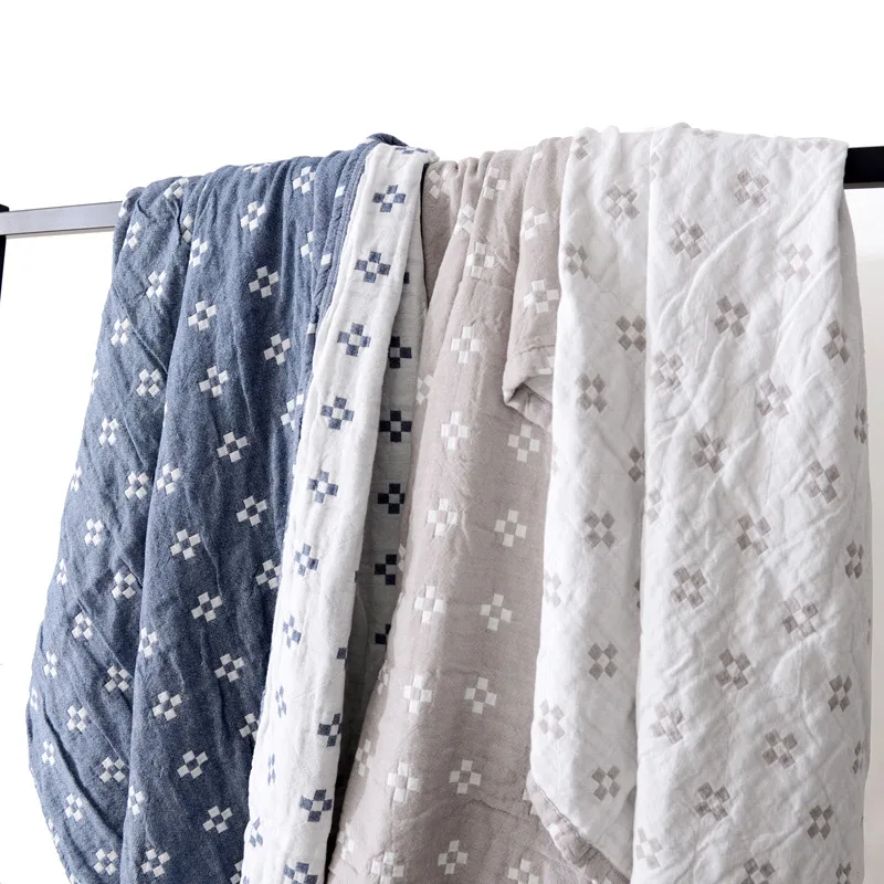 Blue and gray cotton blankets hung over a rail, each showing its colored face and its cream reverse