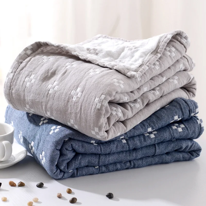 Gray and blue diamond dot blankets folded and stacked, the cream reverse showing at the folds