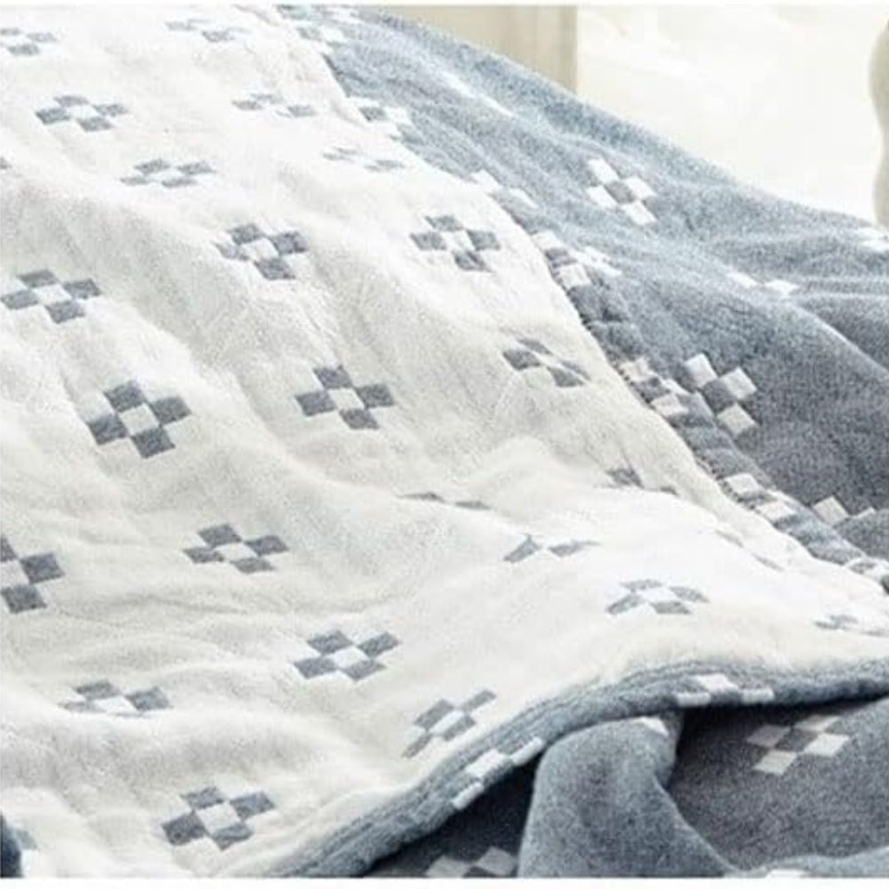 Close-up of the cream reverse with blue diamonds lying over the blue face of the blanket