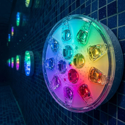 Submersible LED pool light on a dark mosaic tile wall with more lights glowing behind it