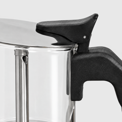 Close-up of the stainless steel lid, black thumb lever and black handle of a glass moka pot