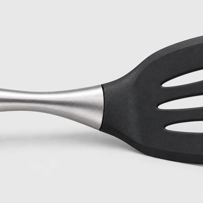 Close-up of a brushed stainless steel handle meeting the black head of a slotted turner