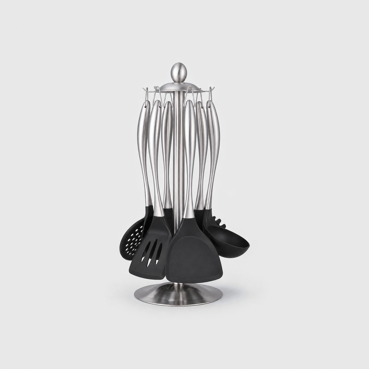 Silver cooking utensil set hanging head-down on a brushed steel stand, on a light gray background