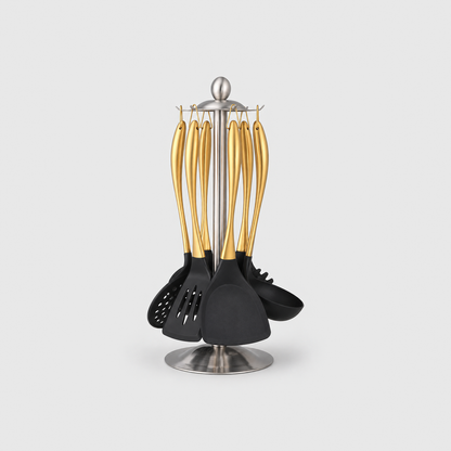 Gold-tone cooking utensil set hanging on a silver steel stand, on a light gray background