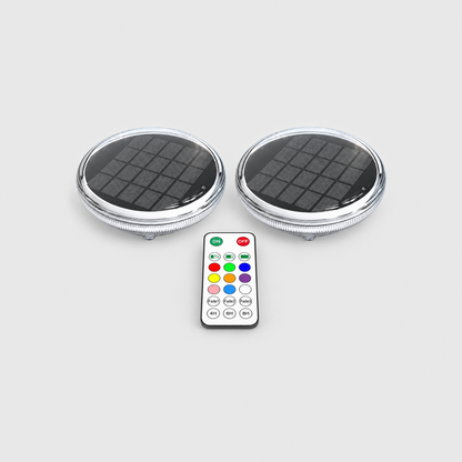 Two solar floating pool lights and one remote control on a light gray background