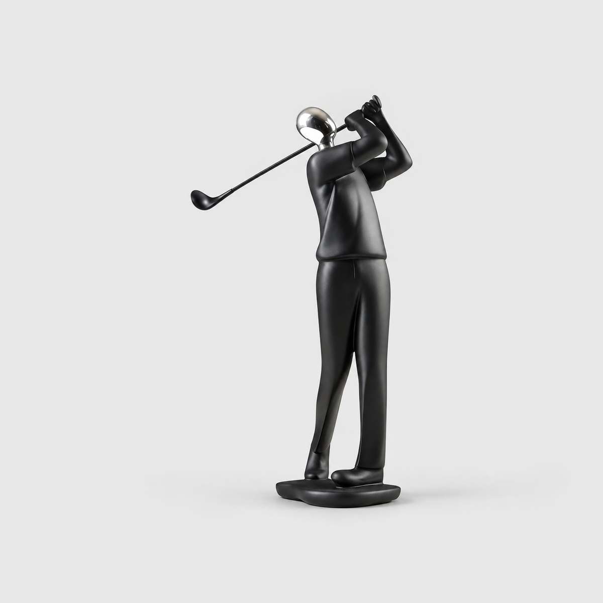 A matte black golfer sculpture with a mirror silver head at the end of a swing, on a light gray background