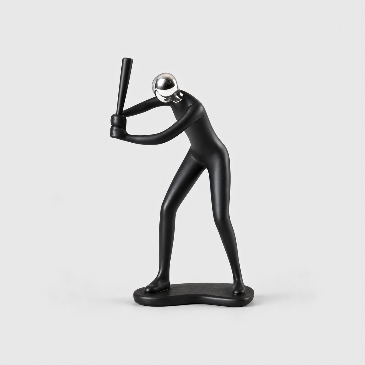 A matte black baseball batter sculpture holding the bat up beside the head, on a light gray background