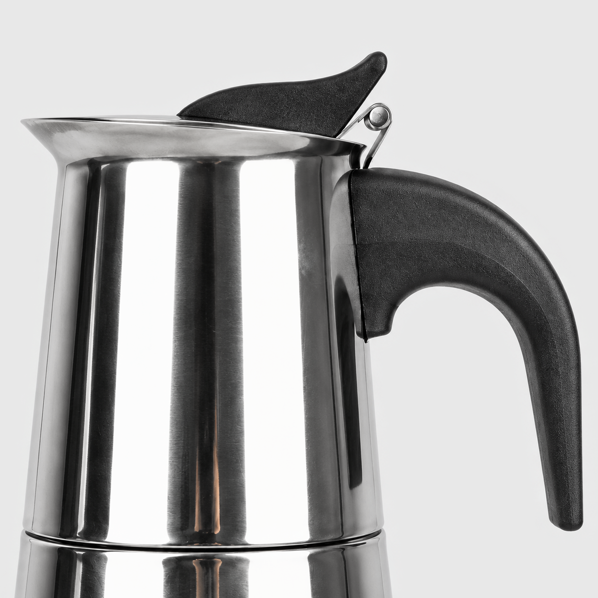 Side view close-up of a moka pot's black heat-resistant handle, hinged lid and thumb tab
