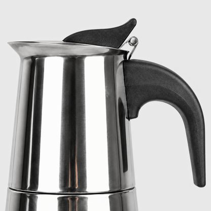 Side view close-up of a moka pot's black heat-resistant handle, hinged lid and thumb tab