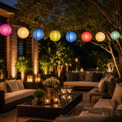 Multicolor lanterns lit across a patio lounge with candles and garden lights at night