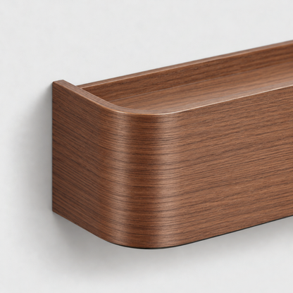 Close-up of the rounded corner and low rim of the walnut wall shelf