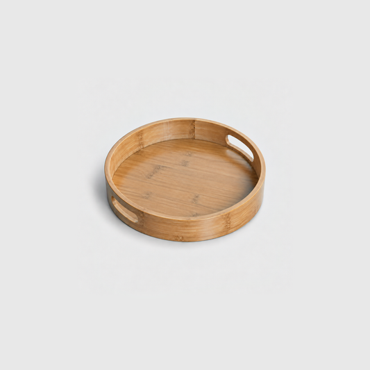 Small round bamboo serving tray with two cut-out handles and a raised edge, on a light gray background