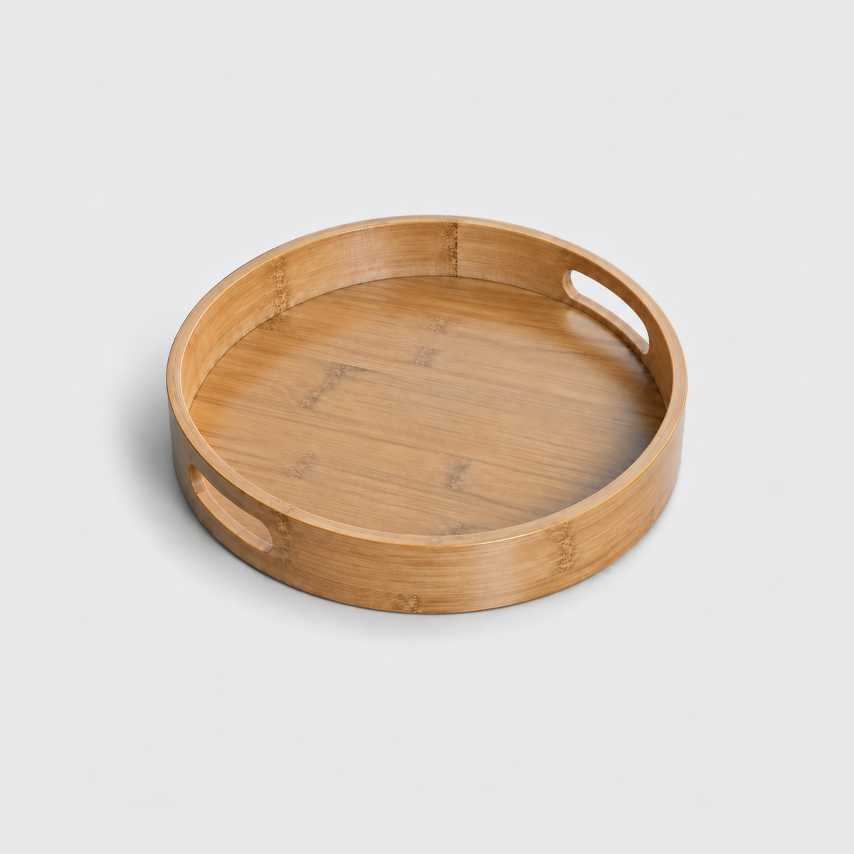 Large round bamboo serving tray with two cut-out handles, on a light gray background
