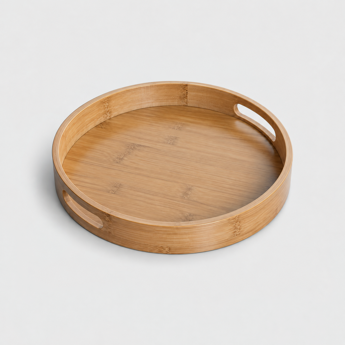 Extra large round bamboo serving tray with two cut-out handles, on a light gray background