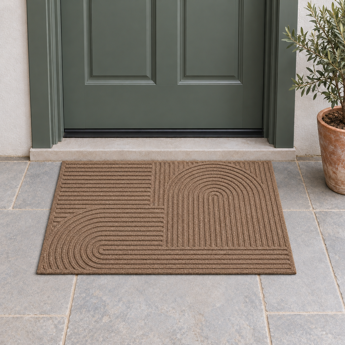 Brown grooved doormat with a raised arc pattern on a stone porch in front of a green-gray front door