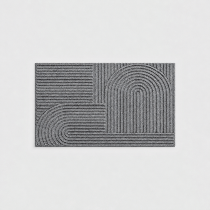 Gray grooved doormat with a raised arc pattern, seen from above on a light gray background