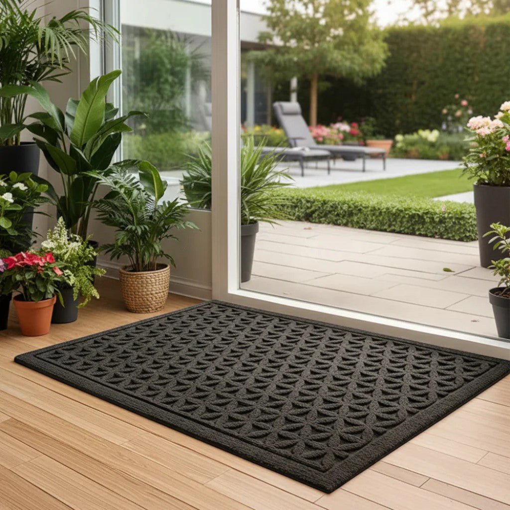 Black grooved doormat with a raised lattice pattern inside an open glass door to the garden