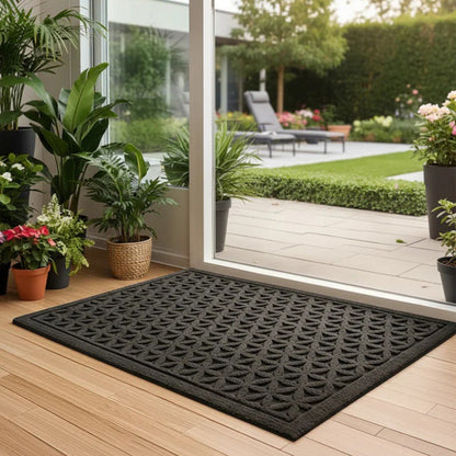 Black grooved doormat with a raised lattice pattern inside an open glass door to the garden
