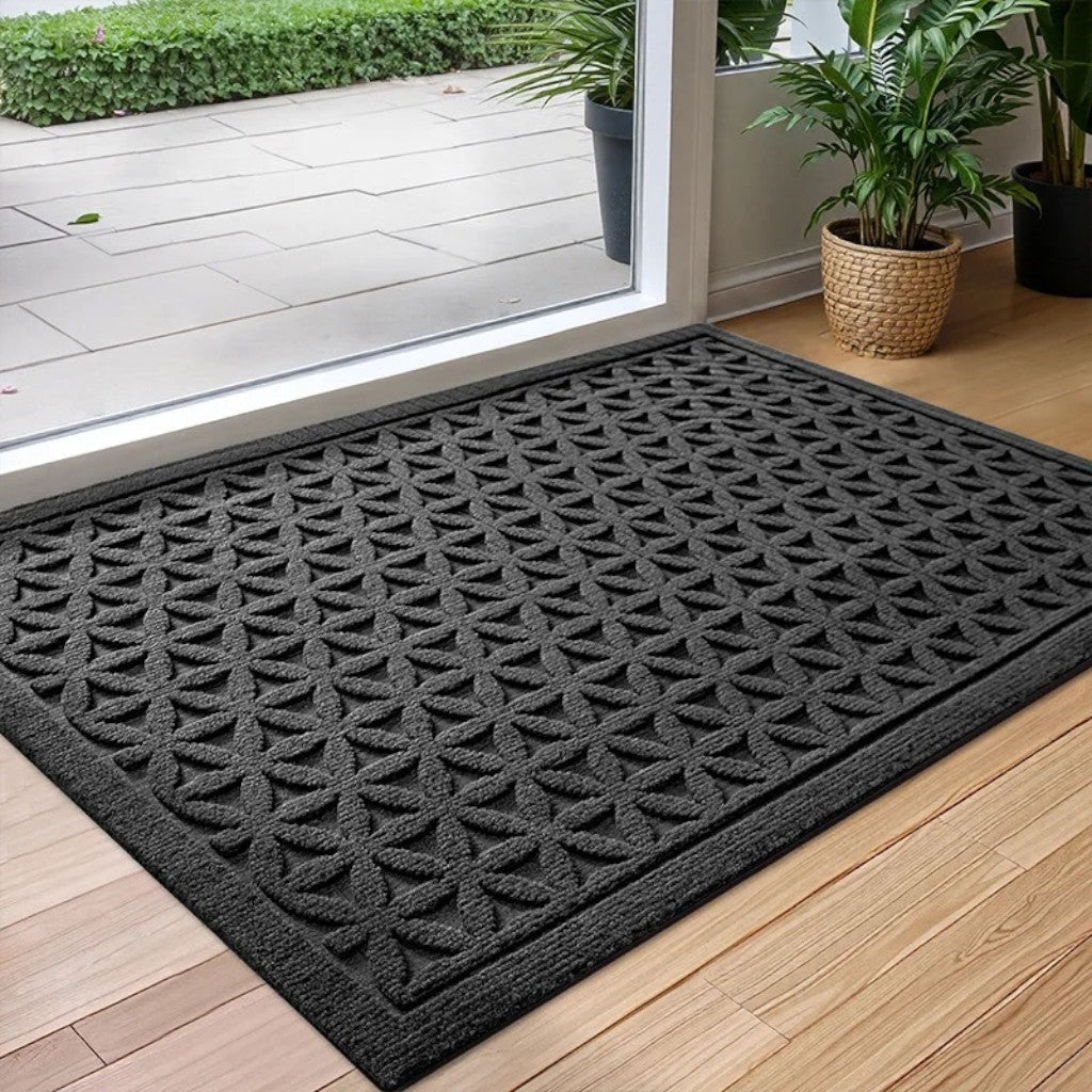 Black grooved doormat with a raised lattice pattern at a glass door