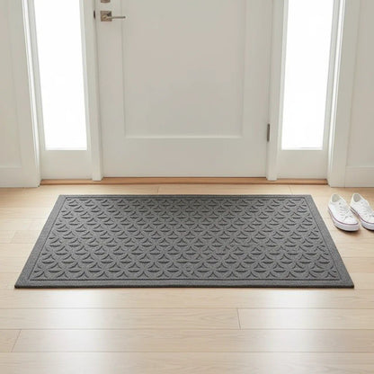 Gray grooved doormat with a raised lattice pattern inside a white front door