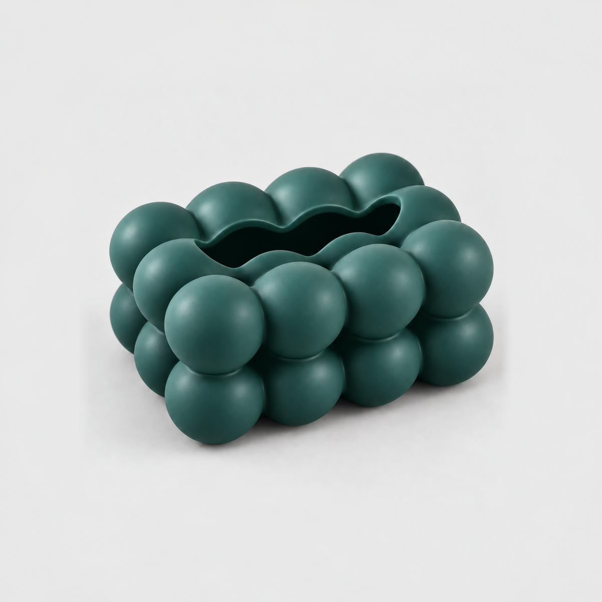 Empty teal bubble tissue box cover seen from above, showing the long scalloped slot along its top