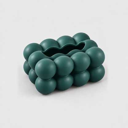 Empty teal bubble tissue box cover seen from above, showing the long scalloped slot along its top
