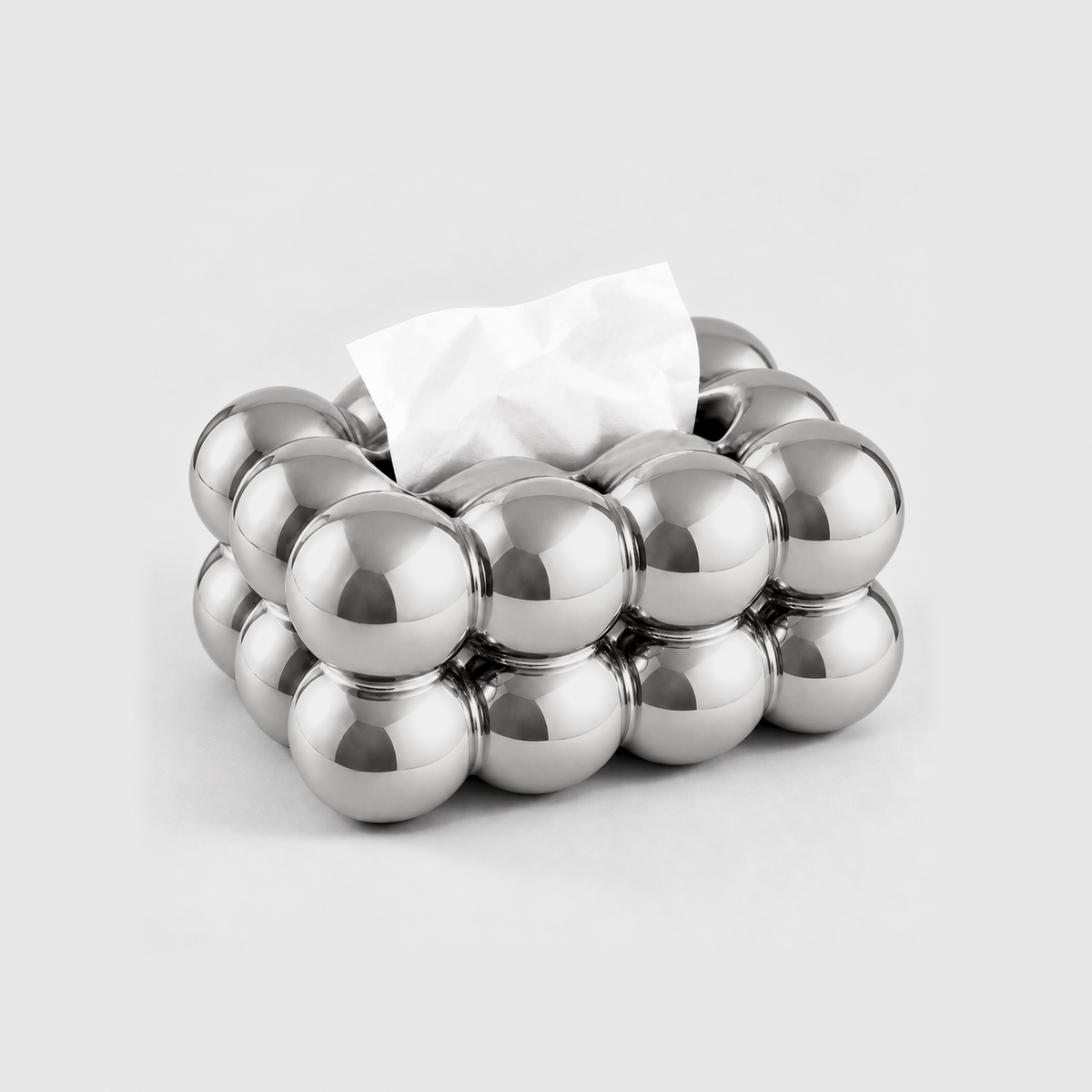 Silver bubble tissue box cover with a mirror finish and a tissue in its top slot, on a light gray background