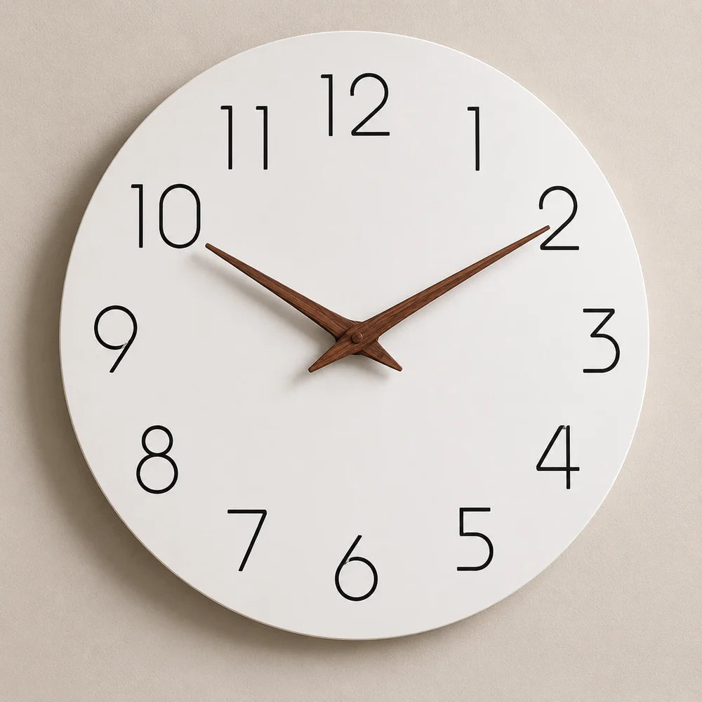 A white wall clock with brown wooden hands hung on a warm beige wall