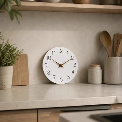 The white clock with wooden hands standing on a kitchen counter against the backsplash