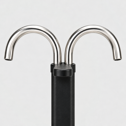 Close-up of the two curved stainless steel spouts rising from the black column of a mini moka pot