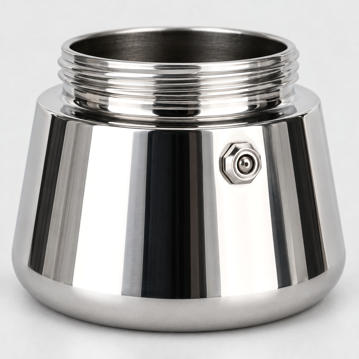 Close-up of the small valve on the polished stainless steel base of a mini moka pot